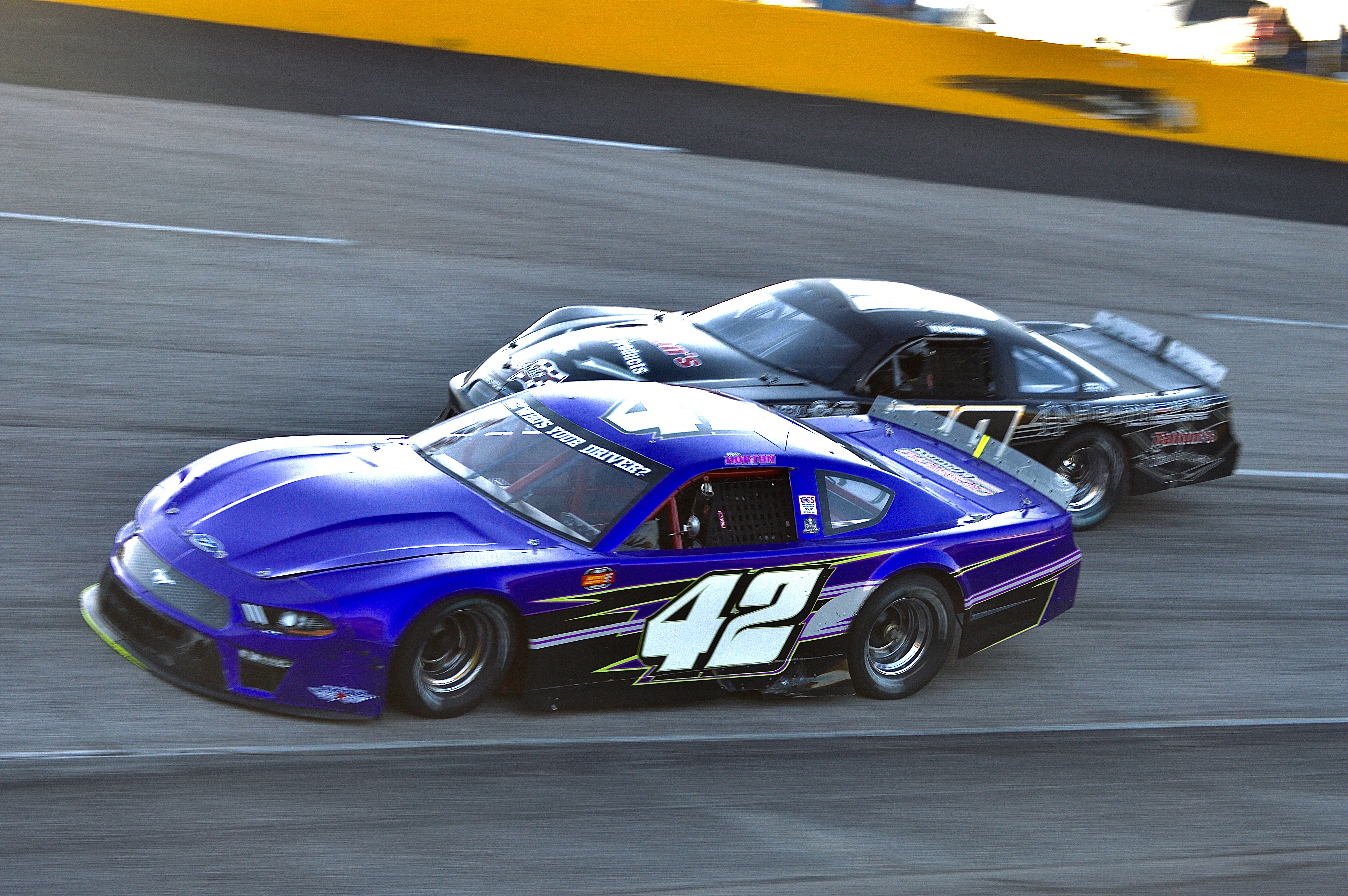 The blue #42 racing wheel to wheel with the #7 at dusk