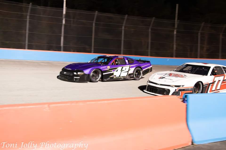 The purple #42 battling the #77 side by side under the lights
