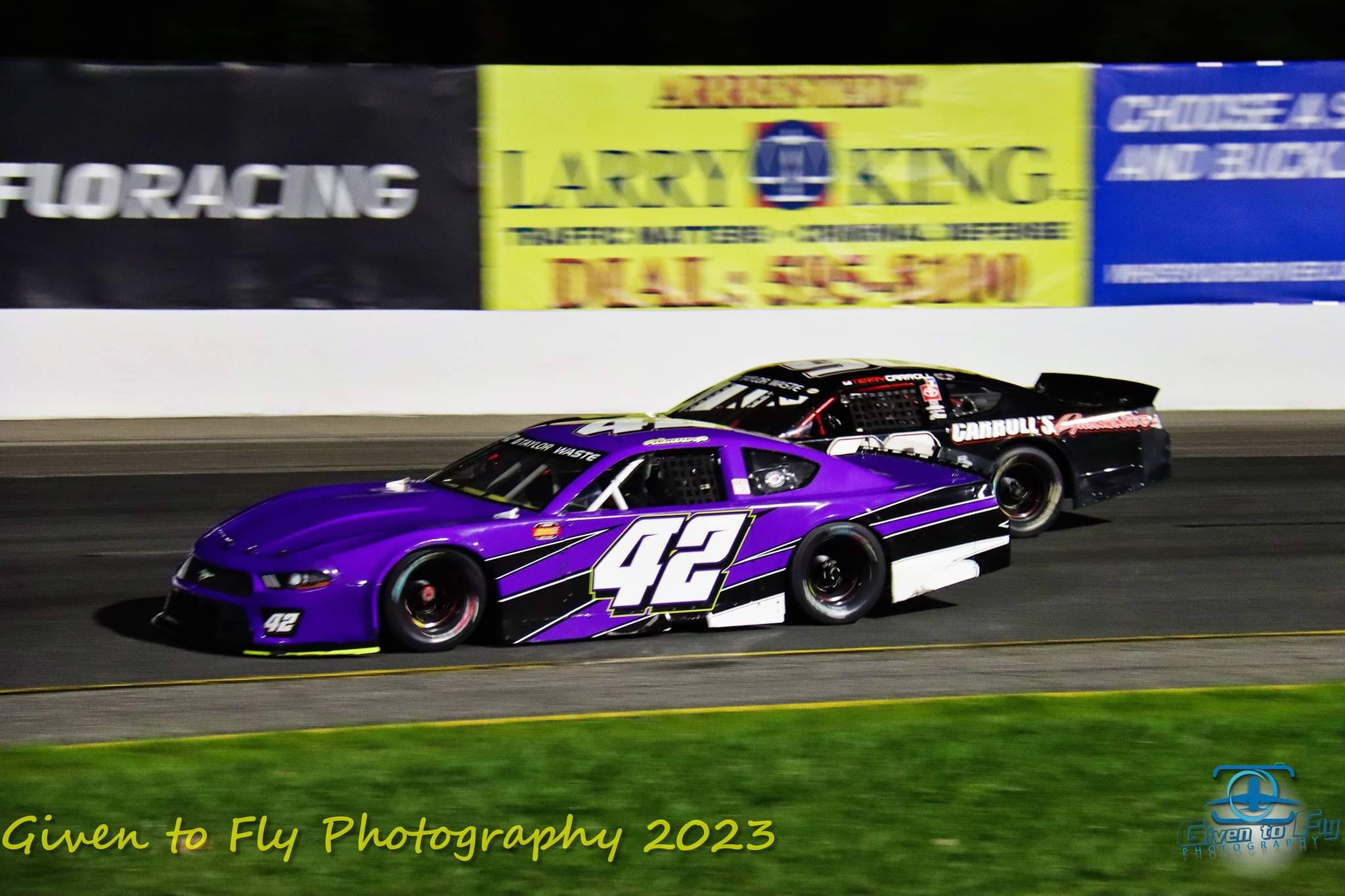 The purple #42 racing under the lights alongside a competitor
