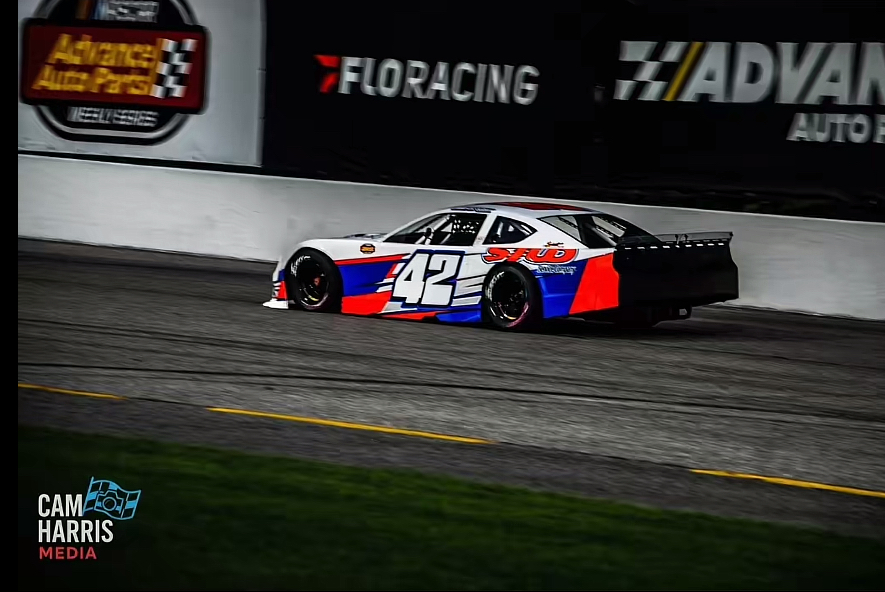 The #42 STUD car at speed under the lights