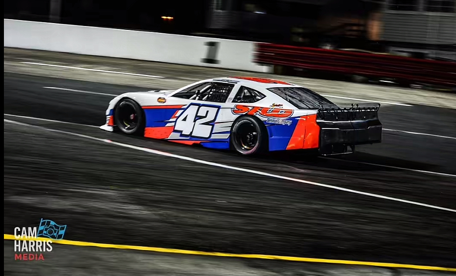 The #42 STUD car powering down the track at night